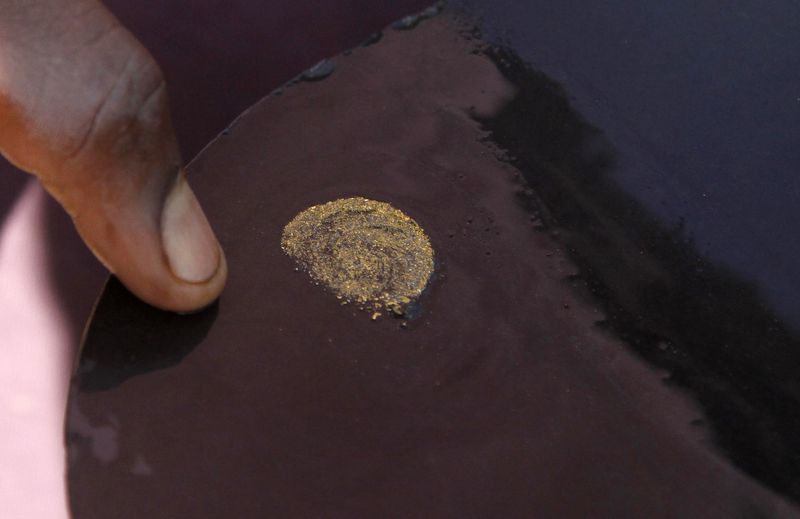 © Reuters. FILE PHOTO: A prospector sorts gold particles found at gold mine in Walungu territory of South Kivu, Democratic Republic of the Congo, May 10, 2014. REUTERS/Kenny Katombe/File Photo