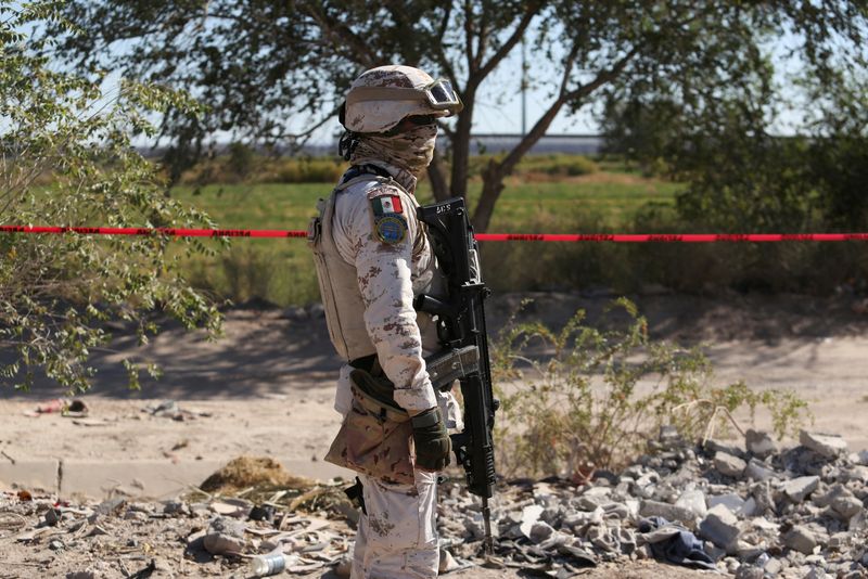 &copy; Reuters. A member of the Mexican Army stands guard at the site where a body was found by residents near an irrigation canal, in Ciudad Juarez, Mexico October 7, 2024. REUTERS/Carlos Sanchez