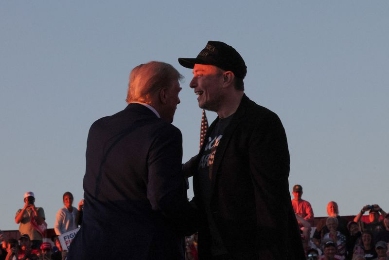 © Reuters. FILE PHOTO: Tesla CEO and X owner Elon Musk stands with Republican presidential candidate former US President Donald Trump during a campaign rally on the day Trump returns to the site of his assassination attempt of July against him in Butler, Pennsylvania, U.S., October 5, 2024. REUTERS/Brian Snyder/File Photo