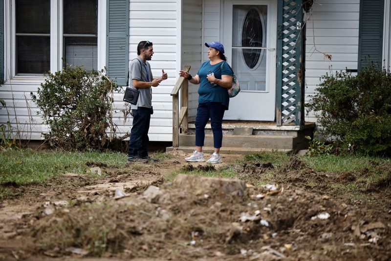 © Reuters. FILE PHOTO: A FEMA employee talks with a woman whose rental home was badly damaged by flooding from Hurricane Helene in Canton, North Carolina, U.S., October 3, 2024. REUTERS/Jonathan Drake/File Photo