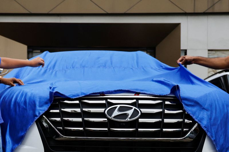 © Reuters. FILE PHOTO: A family unveils a new Hyundai car at one of the motor group's showrooms in New Delhi, India September 6, 2024. REUTERS/Ainnie Arif/File Photo