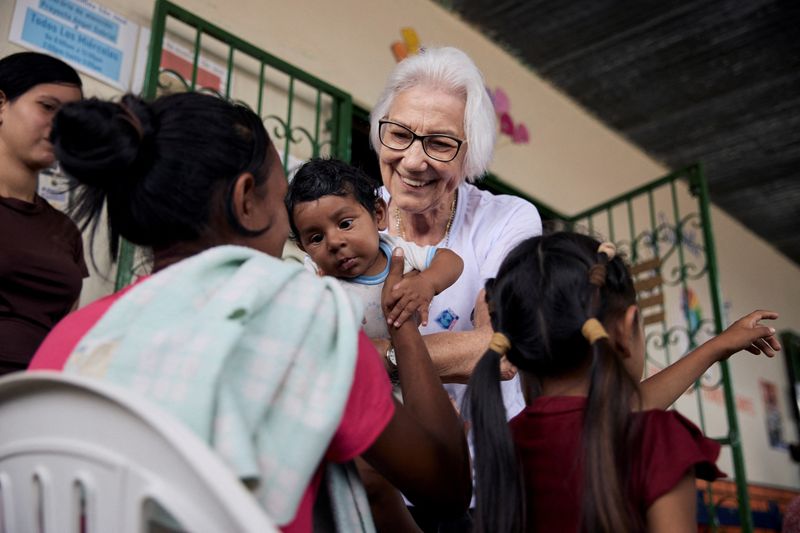 © Reuters. Brazilian nun Sister Rosita Milesi, who is the Global Laureate of the 2024 UNHCR Nansen Refugee Award, holds baby Daniel Jose Milaro, who has just arrived from Venezuela with his mother Jenifer Milaro and siblings, at the Casa de Acolhida Sao Jose, a temporary shelter for refugees and migrants in Pacaraima, Brazil, August 24, 2024. UNHCR/Marina Calderon/Handout via REUTERS