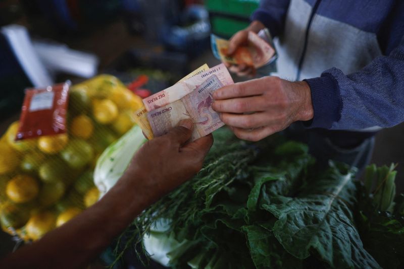 &copy; Reuters. FILE PHOTO: A man pays a vendor at a fruit stand, at a supply centre (CEASA) in Brasilia, Brazil May 9, 2023. REUTERS/Adriano Machado/File Photo