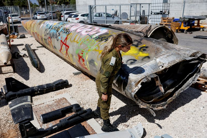 © Reuters. An Israeli soldier stands next to the remains of an Emad ballistic missile at Julis army base, days after an attack by Iran on Israel, in southern Israel, October 9, 2024. REUTERS/Amir Cohen