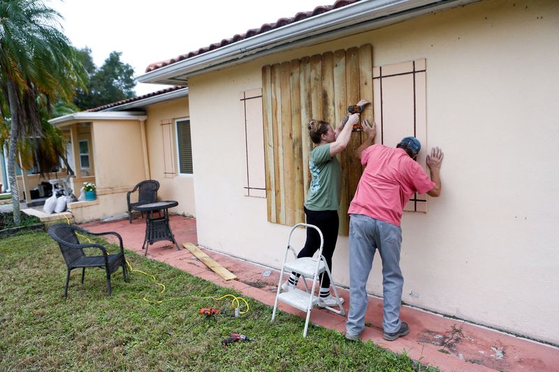 © Reuters. Sofia Andreeva and her uncle Ivaylo Kanchev board up their home ahead of the arrival of Hurricane Milton in St. Petersburg, Florida, U.S., October 8, 2024. REUTERS/Octavio Jones