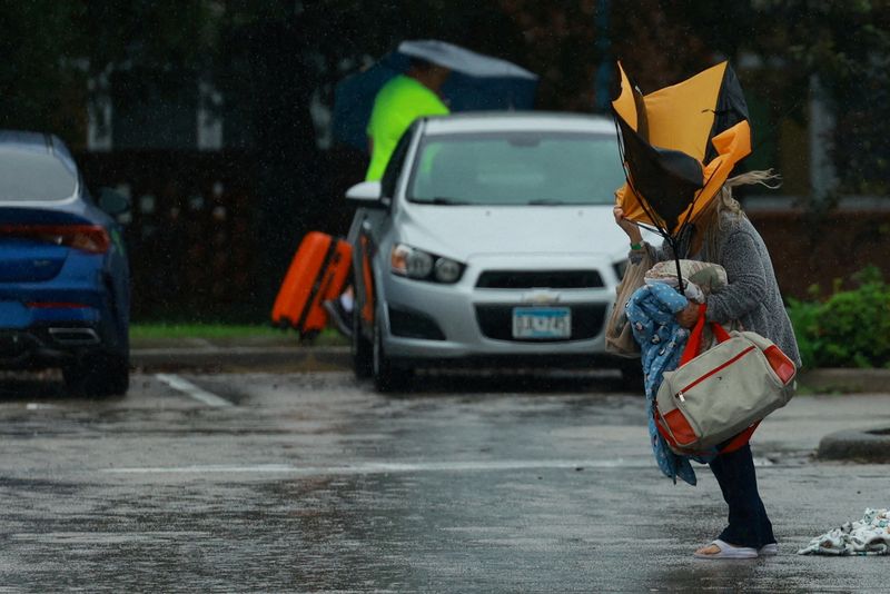 &copy; Reuters. A woman holds an umbrella while arriving at a shelter as Hurricane Milton approaches, in Lakeland, Florida, U.S., October 9, 2024.  REUTERS/Jose Luis Gonzalez