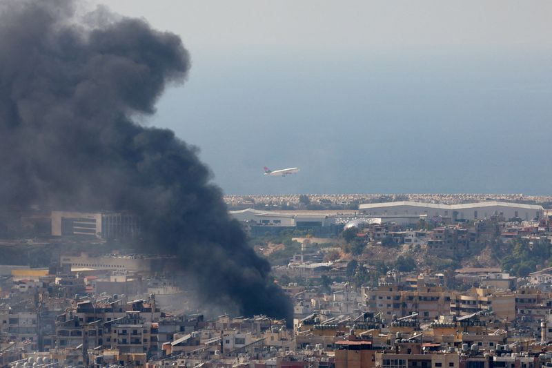 © Reuters. FILE PHOTO: Smoke rises in Beirut's southern suburbs after a strike, as a plane takes off from Rafic Hariri International Airport, amid the ongoing hostilities between Hezbollah and Israeli forces, as seen from Hadath, Lebanon, October 8, 2024. REUTERS/Mohamed Azakir/File Photo