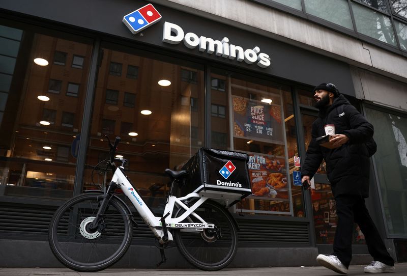 © Reuters. FILE PHOTO: A person walks past a Domino's pizza restuarant in London, Britain, March 4, 2023. REUTERS/Henry Nicholls/File Photo