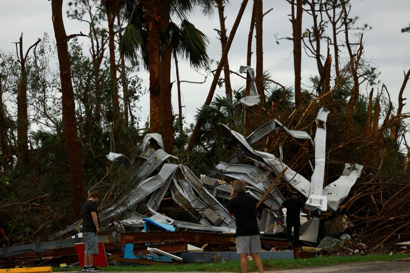 © Reuters. People look at the damage caused by a tornado after Hurricane Milton made landfall, in Lakewood Park, near Fort Pierce, in St. Lucie County, Florida, U.S., October 10, 2024.  REUTERS/Jose Luis Gonzalez