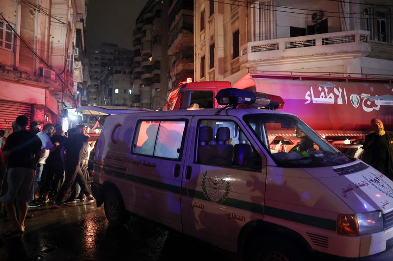 &copy; Reuters. People stand near rescue vehicles at the site of an Israeli air strike, amid ongoing hostilities between Hezbollah and Israeli forces, in Ras Al- Nabaa, in Beirut, Lebanon, October 10, 2024. REUTERS/Louisa Gouliamaki