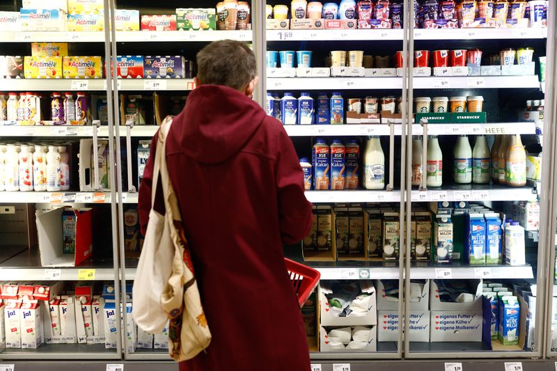 © Reuters. FILE PHOTO: A customer looks at a shelve with dairy products at a Rewe grocery store in Potsdam, Germany, March 20, 2020. REUTERS/Michele Tantussi/File Photo