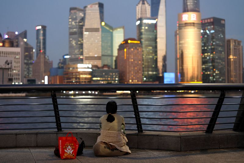 &copy; Reuters. A woman sits on the Bund near Huangpu river as she looks on the financial district of Pudong in Shanghai, China September 27, 2024. REUTERS/Tingshu Wang/File Photo