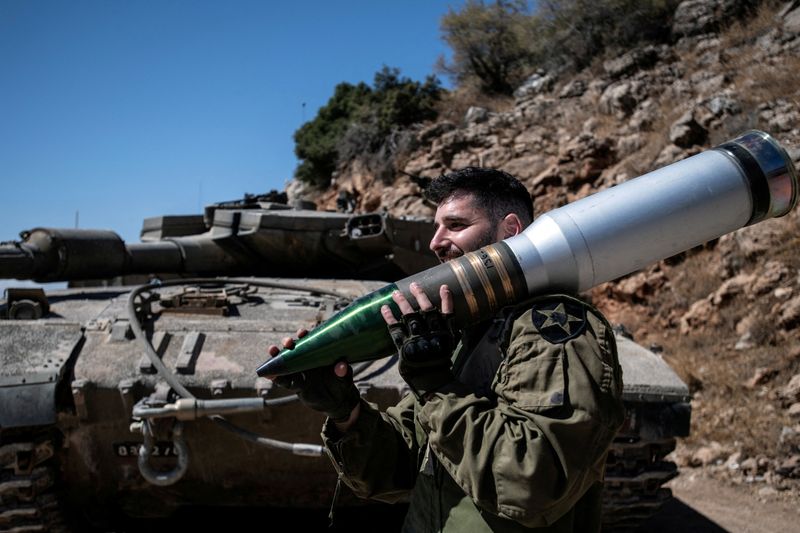 &copy; Reuters. FILE PHOTO: An Israeli soldier carries a shell, amid cross-border hostilities between Hezbollah and Israel, in northern Israel, October 7, 2024. REUTERS/Gil Eliyahu/File Photo