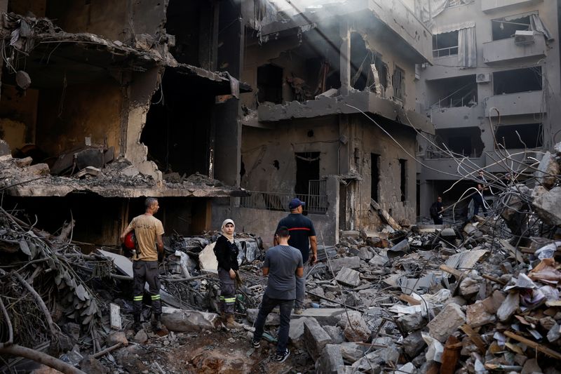 © Reuters. People inspect the site of an Israeli air strike, amid ongoing hostilities between Hezbollah and Israeli forces, in Beirut, Lebanon, October 11, 2024. REUTERS/Louisa Gouliamaki