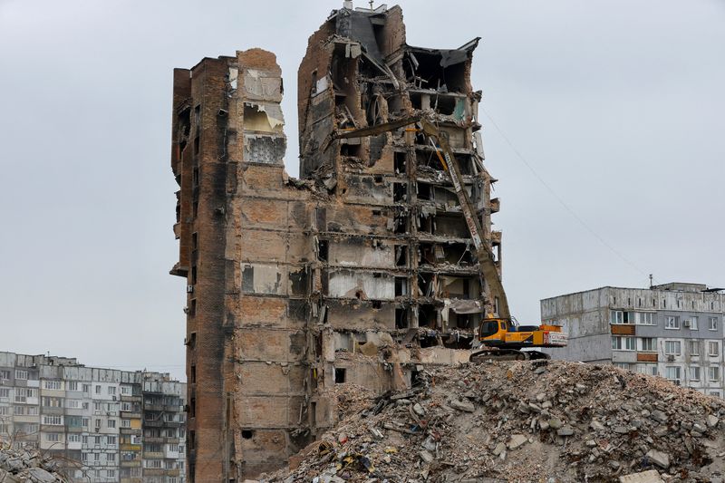 © Reuters. FILE PHOTO: An xcavator demolishes a multi-storey apartment block, which was destroyed in the course of Russia-Ukraine conflict, in Mariupol, Russian-controlled Ukraine, March 16, 2023. REUTERS/Alexander Ermochenko/File Photo