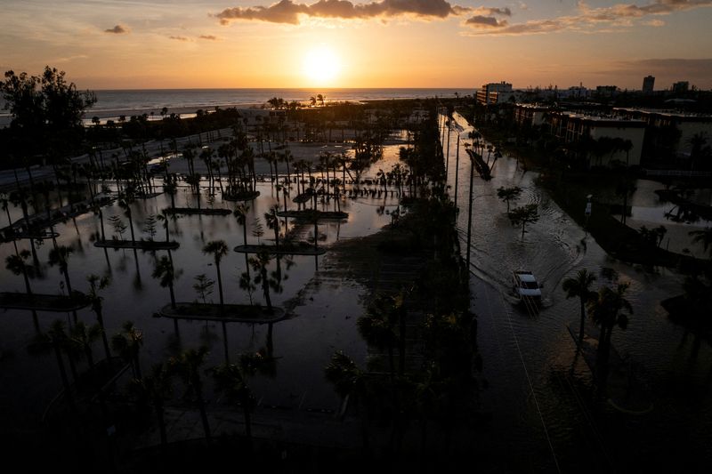 © Reuters. FILE PHOTO: A drone view of a pick-up truck driving through a flooded street following Hurricane Milton in Siesta Key, Florida, U.S., October 10, 2024.  REUTERS/Marco Bello/File Photo