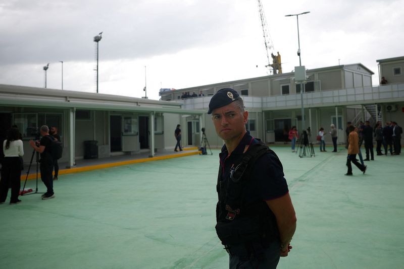 © Reuters. An Italian police officer stands inside the reception camp at the port where Italy will process illegal migrants, in Shengjin, Albania October 11, 2024. REUTERS/Florion Goga