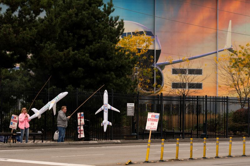 &copy; Reuters. Boeing workers Maria Hamshaw and Tim Mattingly, who are siblings, hold inflatable airplanes on a picket line near the entrance to a Boeing production facility in Renton, Washington, U.S. October 11, 2024. REUTERS/David Ryder