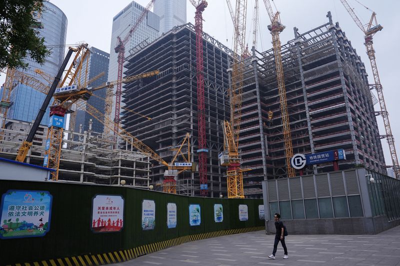 &copy; Reuters. A person walks past a construction site in Beijing's Central Business District (CBD), China July 14, 2024. REUTERS/Tingshu Wang/File Photo