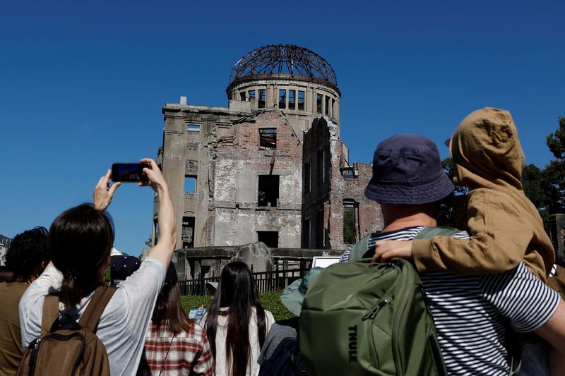 &copy; Reuters. Visitors look at the gutted Atomic Bomb Dome after the U.S. dropped an atomic bomb on the city in 1945 at the Hiroshima Peace Memorial Park, on the following day of The Japan Confederation of A- and H-Bomb Sufferers Organizations (Nihon Hidankyo) winning 