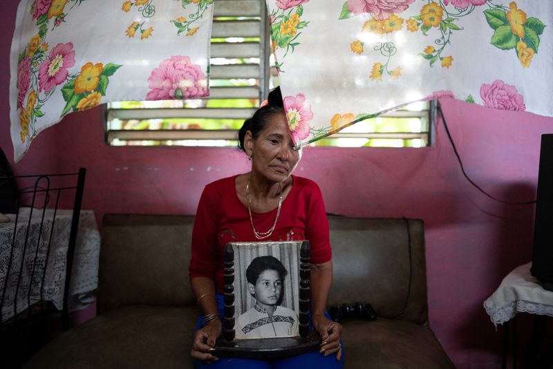 &copy; Reuters. Carmen Llanes poses for a photo with a picture of her son Yonimiler Llanes who went missing in a homemade migrant boat somewhere between Cuba and southern Florida, in Finca Favorito, Cuba, June 19, 2024. REUTERS/Alexandre Meneghini