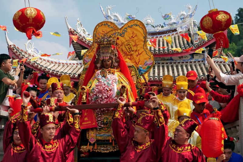 © Reuters. Pilgrims carry a sedan chair holding a statue of the sea goddess Mazu out of a temple during a pilgrimage on Meizhou island, Fujian province, China October 11, 2024. REUTERS/Xiaoyu Yin