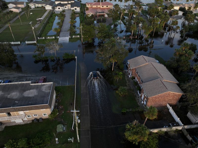 &copy; Reuters. A drone view shows a car driving through a flooded street after Hurricane Milton made landfall in South Daytona, Florida, U.S., October 11, 2024. REUTERS/Ricardo Arduengo   