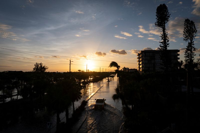 © Reuters. A drone view shows a pick-up truck driving through a flooded street following Hurricane Milton in Siesta Key, Florida, U.S., October 10, 2024.  REUTERS/Marco Bello