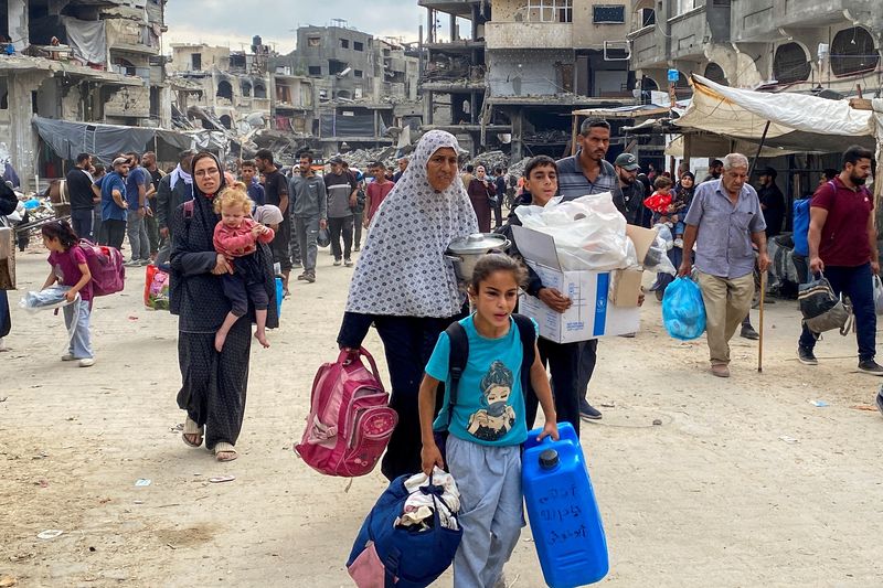 &copy; Reuters. FILE PHOTO: Displaced Palestinians make their way as they flee areas in northern Gaza Strip following an Israeli evacuation order, amid the Israel-Hamas conflict, in Jabalia, October 6, 2024. REUTERS/Hussam Al-Zaanin/File photo