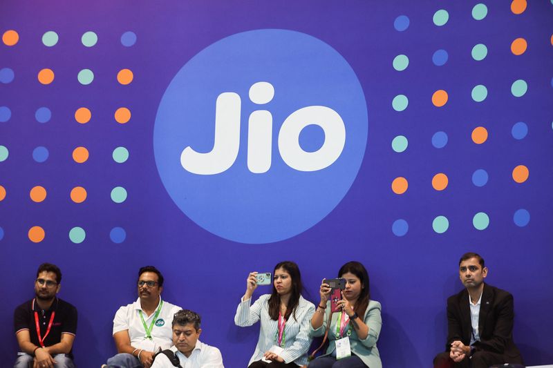 © Reuters. FILE PHOTO: People take pictures with their mobile phones in front of the logo of Jio at the ongoing India Mobile Congress 2022, at Pragati Maidan, in New Delhi, India, October 3, 2022. REUTERS/Anushree Fadnavis/File photo