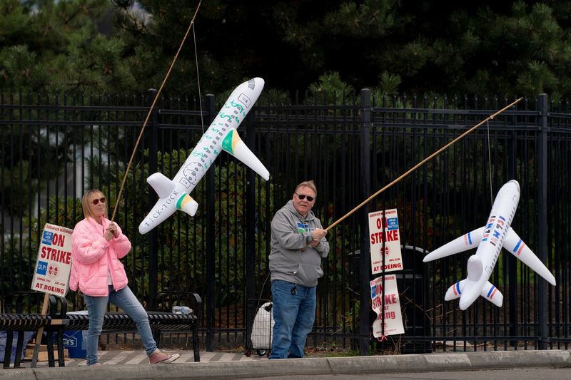 &copy; Reuters. FILE PHOTO: Boeing workers Maria Hamshaw and Tim Mattingly, who are siblings, hold inflatable airplanes on a picket line near the entrance to a Boeing production facility in Renton, Washington, U.S. October 11, 2024. REUTERS/David Ryder/File Photo