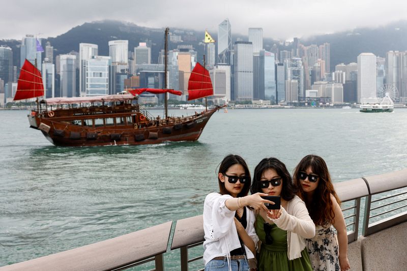 &copy; Reuters. FILE PHOTO: Tourists take photos in front of Victoria Harbour, in Tsim Sha Tsui, in Hong Kong, China April 29, 2024. REUTERS/Tyrone Siu/File Photo