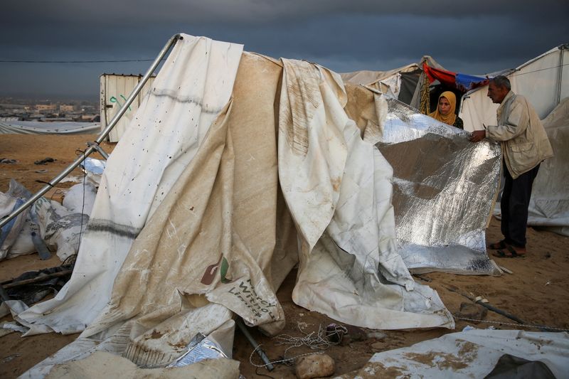 &copy; Reuters. Palestinesi ispezionano i danni sul luogo di un attacco israeliano a una tendopoli che ospitava sfollati, nell'ambito del conflitto in corso tra Israele e Hamas, nell'area di Al-Mawasi a Khan Younis, nel sud della Striscia di Gaza, il 15 ottobre 2024. REU