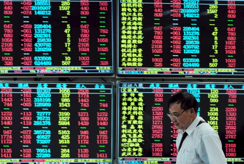 &copy; Reuters. Investidor passa em frente a painel eletrônico com informações do mercado financeiro em corretora de Jiujiang, na província chinesa de Jiangxin16/09/2015 REUTERS/China Daily