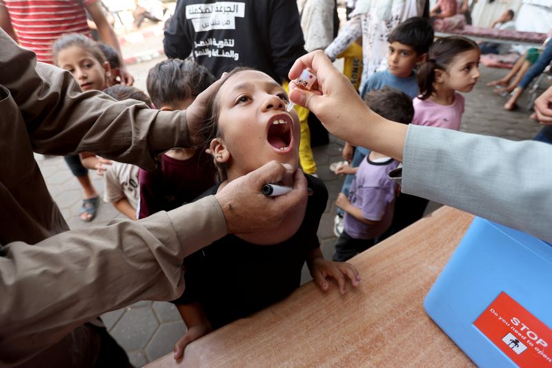 © Reuters. FILE PHOTO: Palestinian child is vaccinated against polio during the second round of a vaccination campaign, amid the Israel-Hamas conflict, in Deir Al-Balah in the central Gaza Strip, October 14, 2024. REUTERS/Ramadan Abed/File Photo