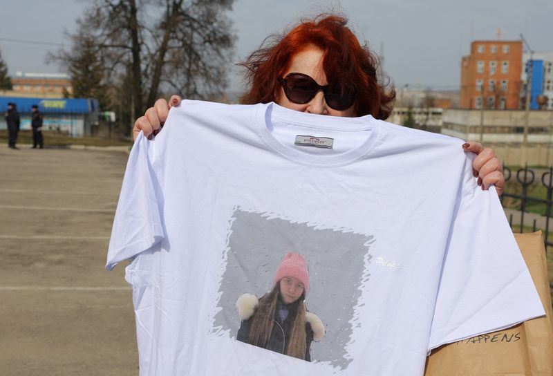 &copy; Reuters. FILE PHOTO: A supporter of Russian citizen Alexei Moskalyov, who was convicted of discrediting the country's armed forces in the course of Russia-Ukraine military conflict, holds a t-shirt with a portrait of Moskalyov's daughter Masha outside a courthouse