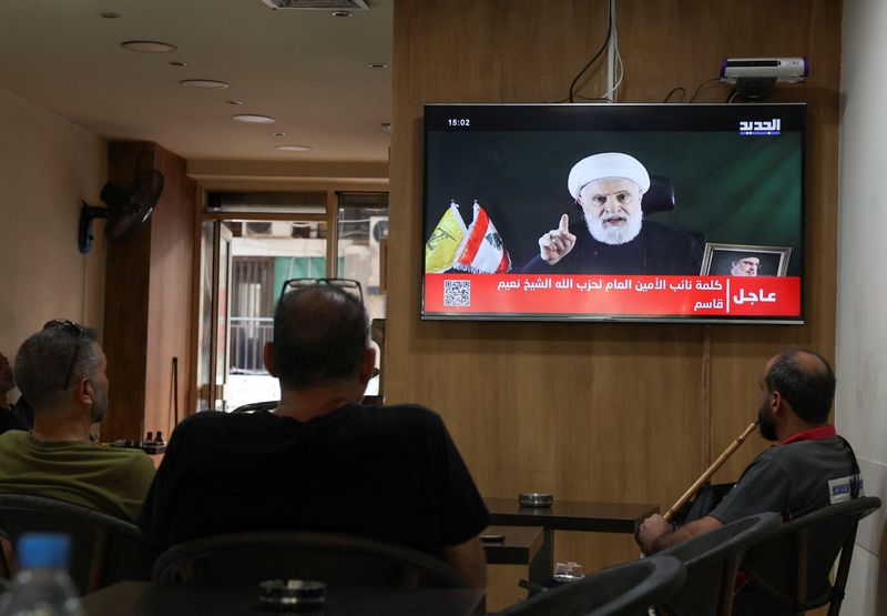 &copy; Reuters. People watch Hezbollah deputy leader Sheikh Naim Qassem delivering a televised address, as they sit in a cafe in Beirut, Lebanon October 15, 2024. REUTERS/Mohamed Azakir