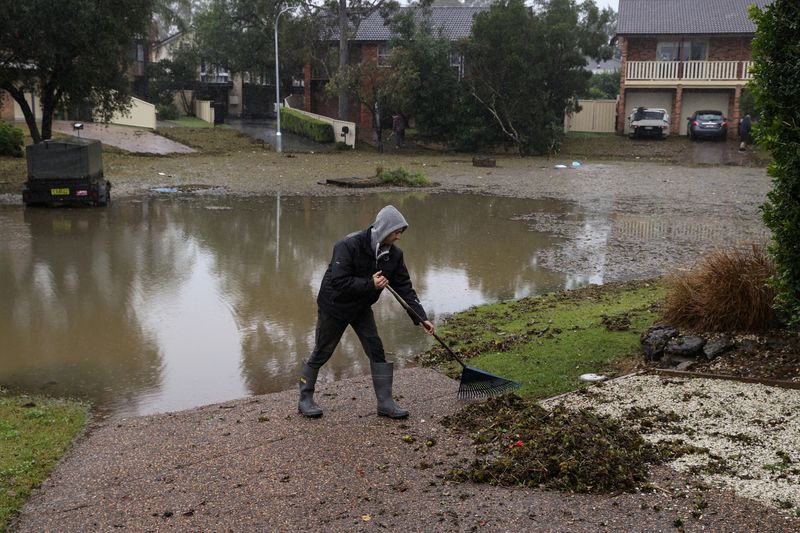 &copy; Reuters. Morador retira entulho em frente de sua casa após águas recuarem depois de enchente em subúrbio de Sydney, na Austrálian06/07/2022 REUTERS/Loren Elliott