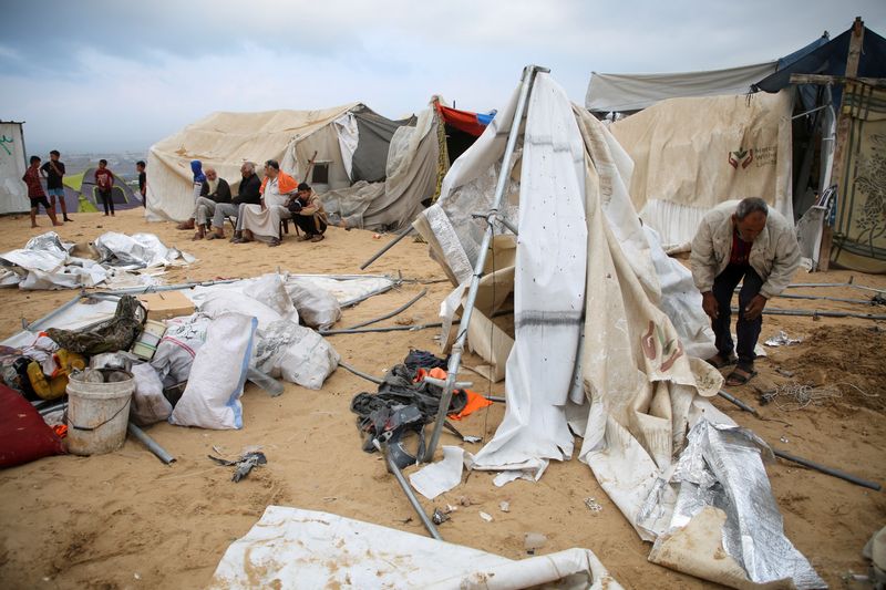 © Reuters. Palestinians inspect the damage at the site of an Israeli strike on a tent camp sheltering displaced people, amid the ongoing Israel-Hamas conflict, in Al-Mawasi area in Khan Younis, in the southern Gaza Strip, October 15, 2024. REUTERS/Hatem Khaled