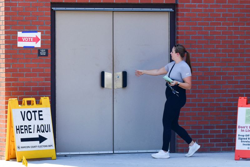 &copy; Reuters. FILE PHOTO: A voter walks into a polling location with an early ballot at Osborn Elementary School in Phoenix, Arizona, U.S., July 30, 2024. REUTERS/Caitlin O'Hara/File Photo