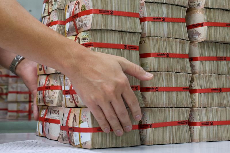 Bank employee collecting Thai baht notes