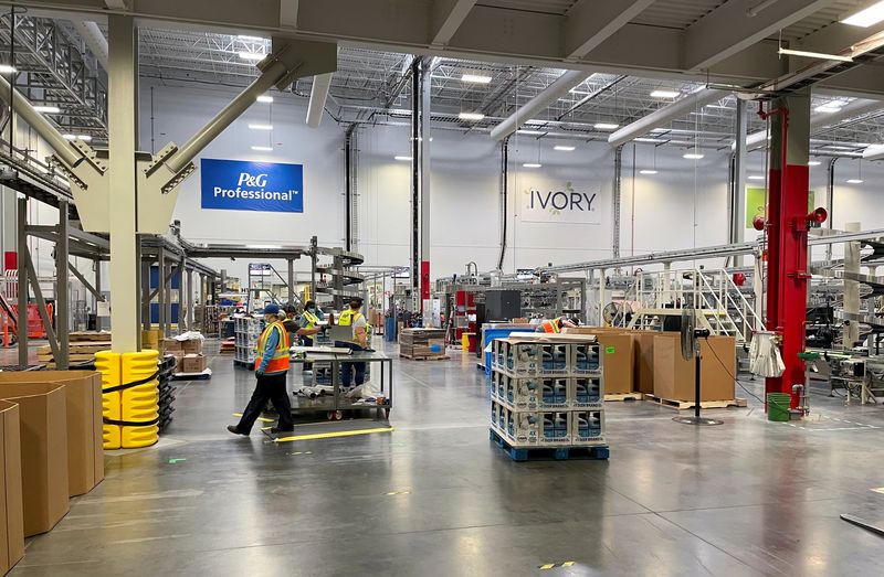 &copy; Reuters. People work with robots at Procter & Gamble's factory in Tabler Station, West Virginia, U.S., May 28, 2021. Picture taken May 28, 2021. REUTERS/Timothy Aeppel/File Photo