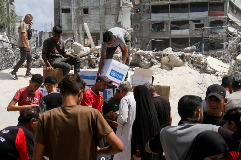 © Reuters. FILE PHOTO: Palestinians gather to receive aid, including food supplies provided by the World Food Program (WFP), outside a UN distribution center, amid the Israel-Hamas conflict, in Jabalia in the northern Gaza Strip, August 24 2024 REUTERS/ Mahmoud Issa/File photo