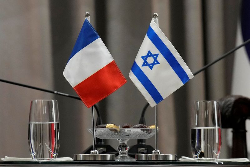 © Reuters. FILE PHOTO: French, left, and Israeli flags are seen as French President Emmanuel Macron meets Israel's President Isaac Herzog in Jerusalem, Tuesday, Oct. 24, 2023. Christophe Ena/Pool via REUTERS/File photo