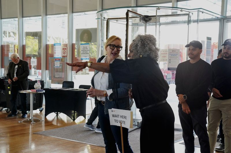 © Reuters. People head to vote at a polling station as Georgians turned out a day after the battleground state opened early voting, in Atlanta, Georgia, U.S., October 16, 2024. REUTERS/Megan Varner