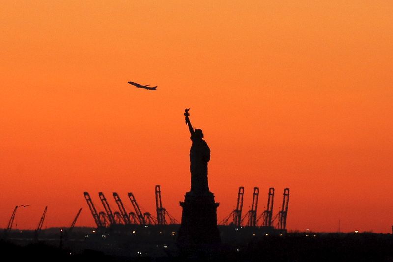 © Reuters. FILE PHOTO: A plane is seen during take off in New Jersey behind the Statue of Liberty in New York's Harbor as seen from the Brooklyn borough of New York February 20, 2016. REUTERS/Brendan McDermid/File Photo