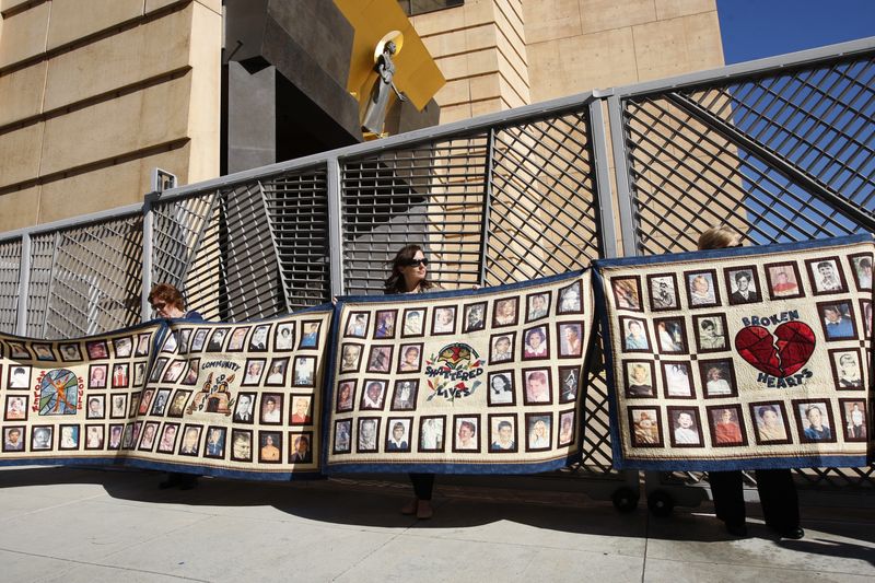 © Reuters. FILE PHOTO: People hold quilts at a press conference outside of Cathedral of Our Lady of the Angels for victims of sexual abuse by priests in the Catholic Archdiocese of Los Angeles in Los Angeles, California, February 1, 2013. REUTERS/David McNew/File Photo