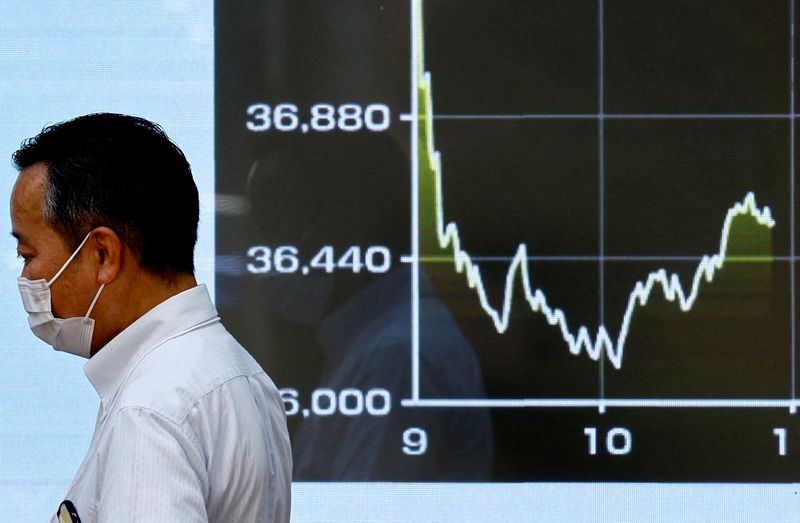 &copy; Reuters. FILE PHOTO: A person walks past an electronic screen displaying the graph showing today's movements of Japan's Nikkei share average outside a brokerage in Tokyo, Japan August 2, 2024. REUTERS/Issei Kato/ File Photo