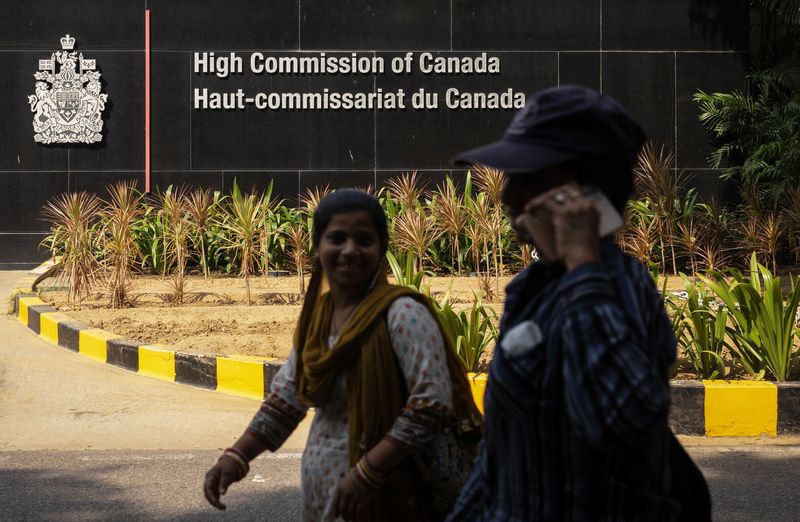 © Reuters. FILE PHOTO: Women walk past the main gate of the Canadian High Commission, in New Delhi, India October 17, 2024. REUTERS/Adnan Abidi/File Photo