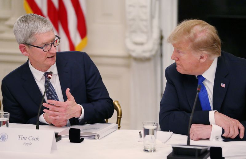 &copy; Reuters. FILE PHOTO: Apple CEO Tim Cook talks with U.S. President Donald Trump as they participate in an American Workforce Policy Advisory Board meeting in the White House State Dining Room in Washington, U.S., March 6, 2019. REUTERS/Leah Millis/File Photo 